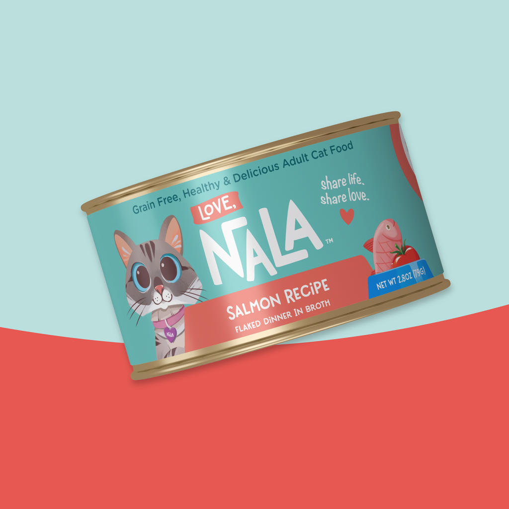A can of NALA Love Salmon Recipe adult cat food, shown at an angle against a split light blue and coral red background.