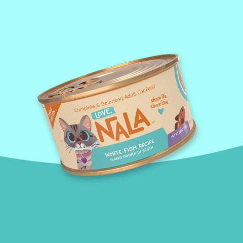 A single can of NALA Love White Fish Recipe adult cat food, shown at an angle on a stylized light blue and teal background.