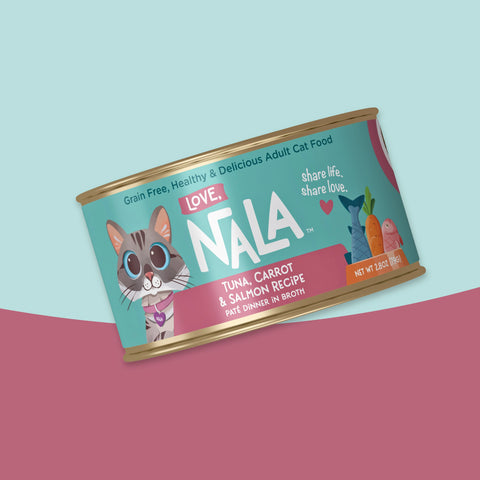 A single can of NALA Love Adult Cat Food, tuna, carrot & salmon recipe, shown at an angle against a split pastel blue and dusty pink background.
