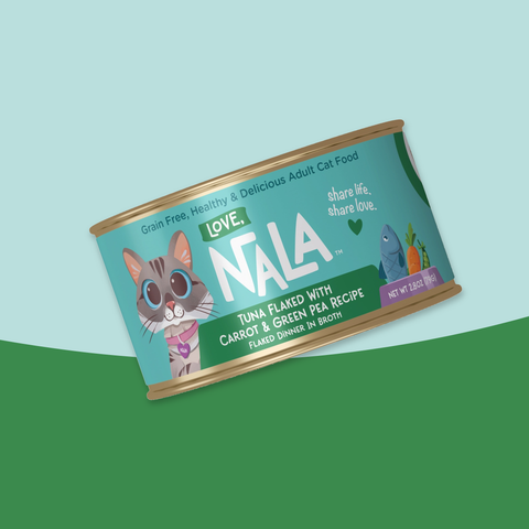 A can of NALA Love Tuna Flaked with Carrot & Green Pea Recipe adult cat food, shown at an angle on a stylized background split diagonally between light blue and coral red.